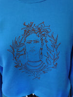 close up of Frida Kahlo line drawing arttwork on turquoise sweatshirt
